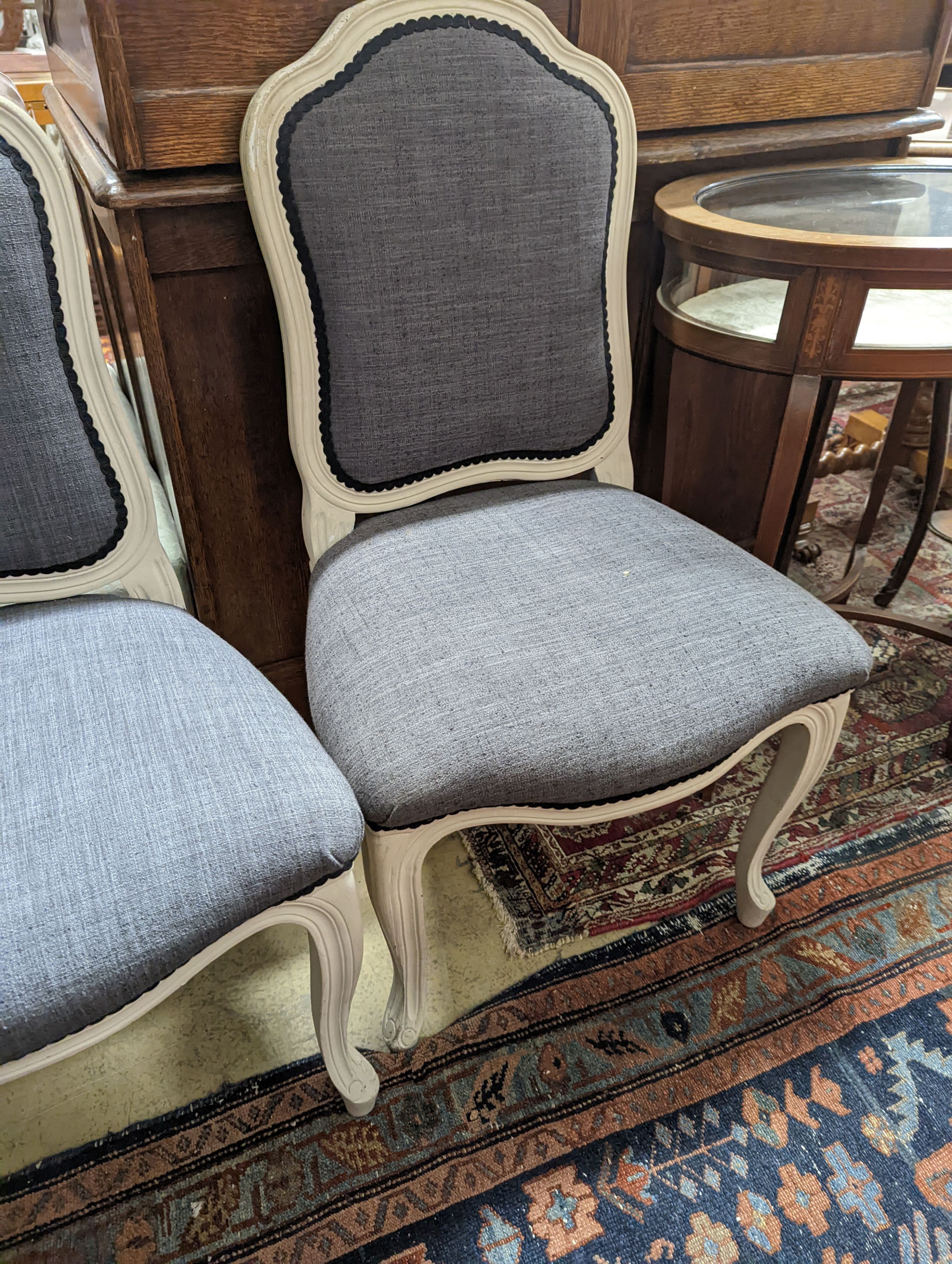 A pair of grey upholstered dining chairs